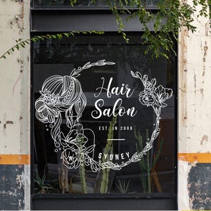 Peut inclure: Une vitrine de magasin blanche avec un motif floral et le texte "Hair Salon Est. in 2009 Sydney".
