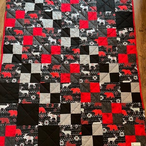 Moose, deer, and bears parade across this unique quilt. The pattern looks like a cozy sweater and this quilt feels just as warm!