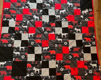 Moose, deer, and bears parade across this unique quilt. The pattern looks like a cozy sweater and this quilt feels just as warm!