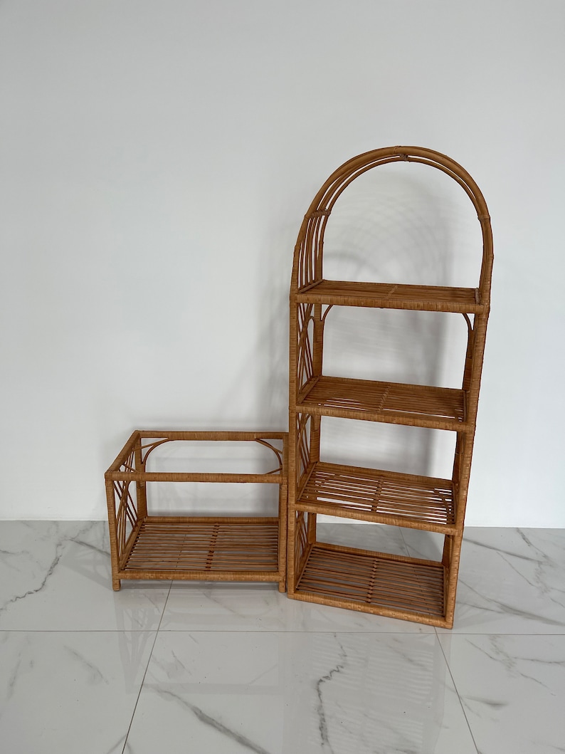May include: Two brown wicker shelves, one with an arched top and four shelves, the other with two shelves. The shelves are made of woven rattan.