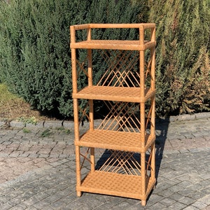 Peut inclure: Une étagère en osier à quatre niveaux avec une finition brun naturel. L'étagère a un motif tissé en forme de diamant et est faite de matériaux naturels.