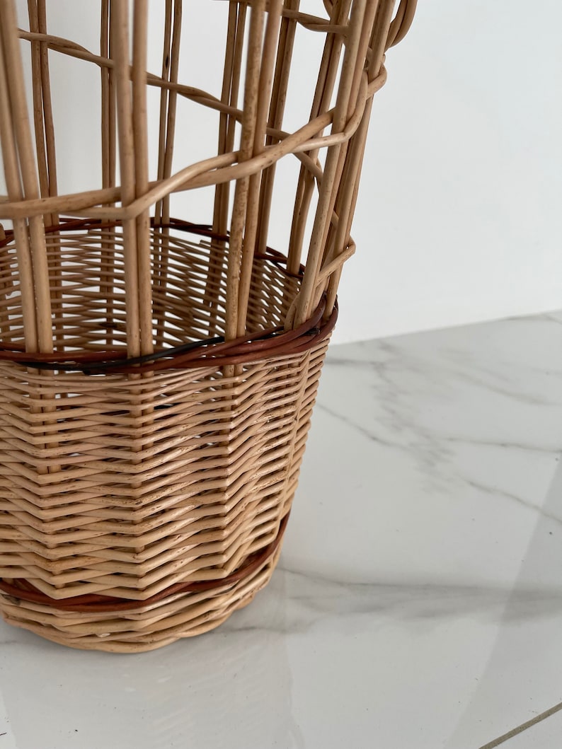 Pu&ograve; includere: Un cesto intrecciato in vimini con un bordo marrone intorno alla parte superiore. Il cesto &egrave; fatto di materiali naturali e ha un aspetto rustico.