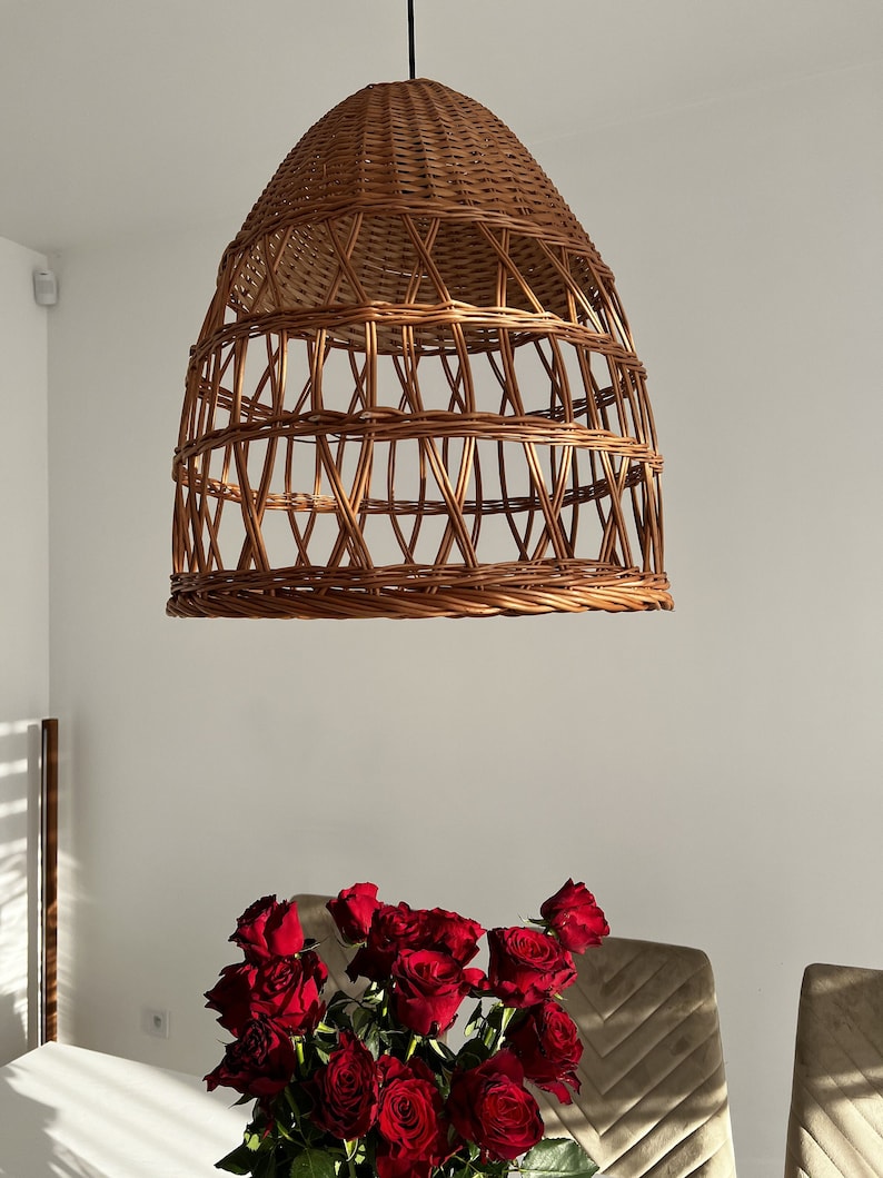 May include: A brown wicker pendant light fixture hangs from the ceiling. The light fixture is shaped like an egg and has a woven pattern.