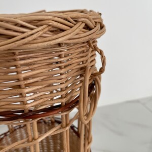 Pu&ograve; includere: Un cesto intrecciato in vimini con una fascia marrone e un manico. Il cesto &egrave; realizzato con materiali naturali e ha un aspetto rustico.
