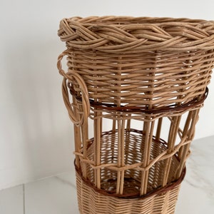 Pu&ograve; includere: Un cesto intrecciato in vimini con un bordo marrone e un manico. Il cesto &egrave; fatto di materiali naturali e ha un aspetto rustico.
