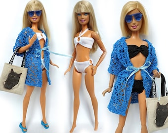 May include: Three Barbie dolls wearing different swimwear and blue crochet cover-ups. One doll is holding a tote bag with a black cat design and the text "NICE NICENESS".