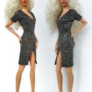 Puede incluir: Dos mu&ntilde;ecas de moda con cabello largo, blanco y rizado, que llevan un vestido plateado brillante con una abertura en la pierna y tacones negros.