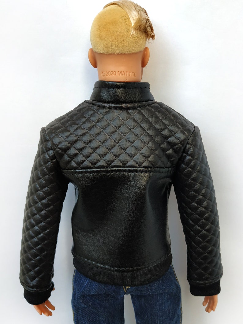 May include: Black quilted jacket with a zipper closure. The jacket has a diamond pattern and a black ribbed knit collar, cuffs, and hem. The jacket is made of faux leather and has the text "&copy;2020 MATTEL" printed on the back.