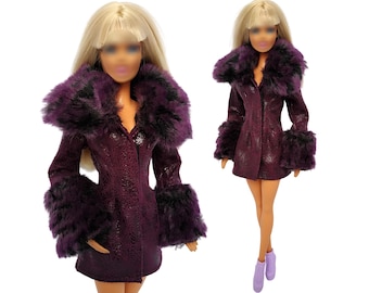 May include: A purple faux fur coat with a black trim. The coat has long sleeves and a collar. The coat is made for a doll.