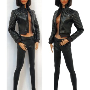 May include: A black leather jacket with a quilted design and a zipper closure. The jacket has a cropped length and features silver studs on the shoulders. The jacket is paired with black leather leggings and black heels.