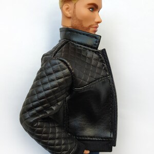 May include: Black quilted leather jacket with a zipper closure. The jacket has a stand-up collar and a ribbed knit cuff.