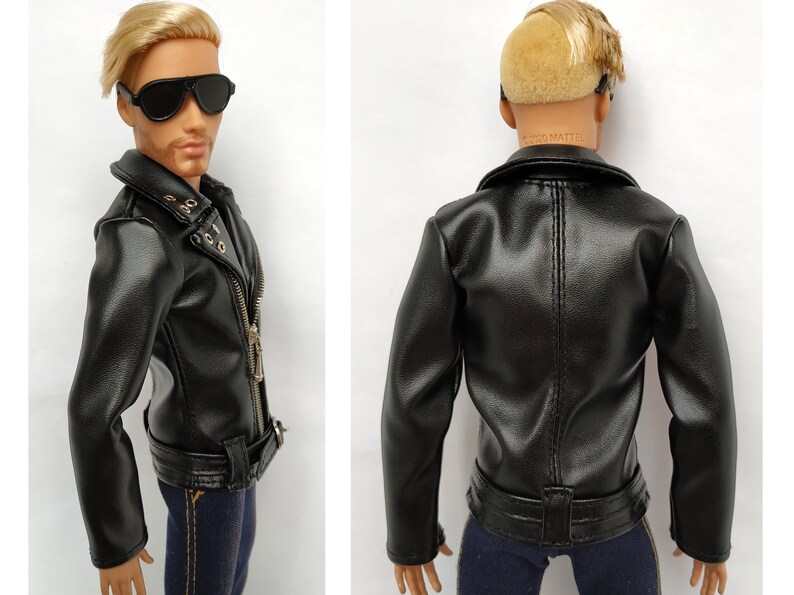 K&ouml;nnte beinhalten: Schwarze Lederjacke mit Rei&szlig;verschluss, G&uuml;rtel und goldenen Akzenten. Die Jacke hat einen Kragen und lange &Auml;rmel.