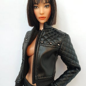 May include: A black faux leather jacket with a quilted design and silver studs. The jacket has a zipper closure and a stand-up collar.