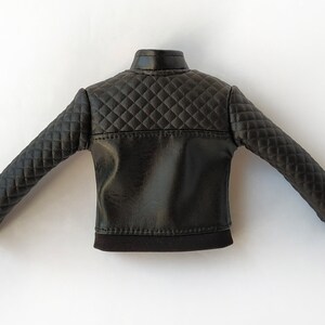 May include: Black quilted leather jacket with a stand-up collar and long sleeves.
