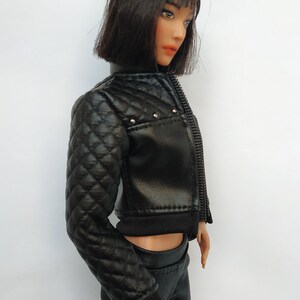 May include: A black quilted leather jacket with a zipper closure and silver studs. The jacket has a cropped style and a black ribbed knit collar.