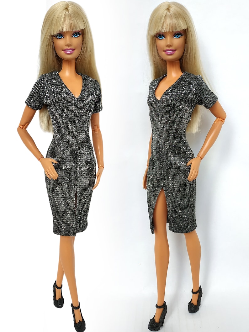 Puede incluir: Dos mu&ntilde;ecas Barbie con un vestido brillante plateado y negro con cuello en V y una abertura en el lateral. Las mu&ntilde;ecas tienen el pelo rubio y los ojos azules.
