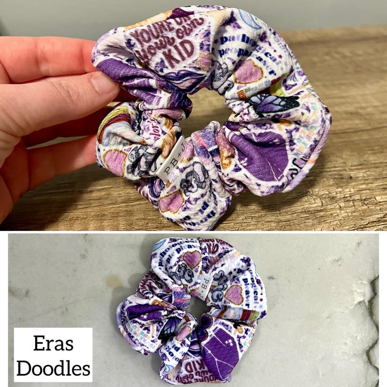 May include: Purple and white scrunchie with a variety of colorful stickers and text, including "You're doing your own kid" and "Eras Doodles".