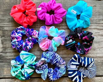 May include: Ten colorful hair scrunchies with a variety of patterns, including floral, tie-dye, and geometric designs. The scrunchies are all made of soft fabric and have a comfortable fit.