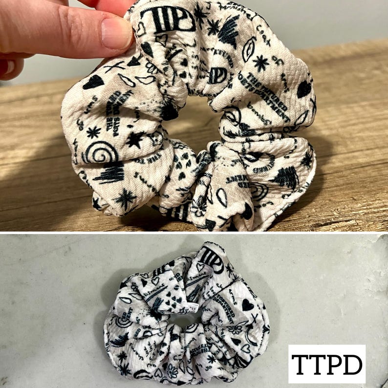 May include: A white scrunchie with black text and symbols. The text includes "The Future Department" and "Cast of Kings".