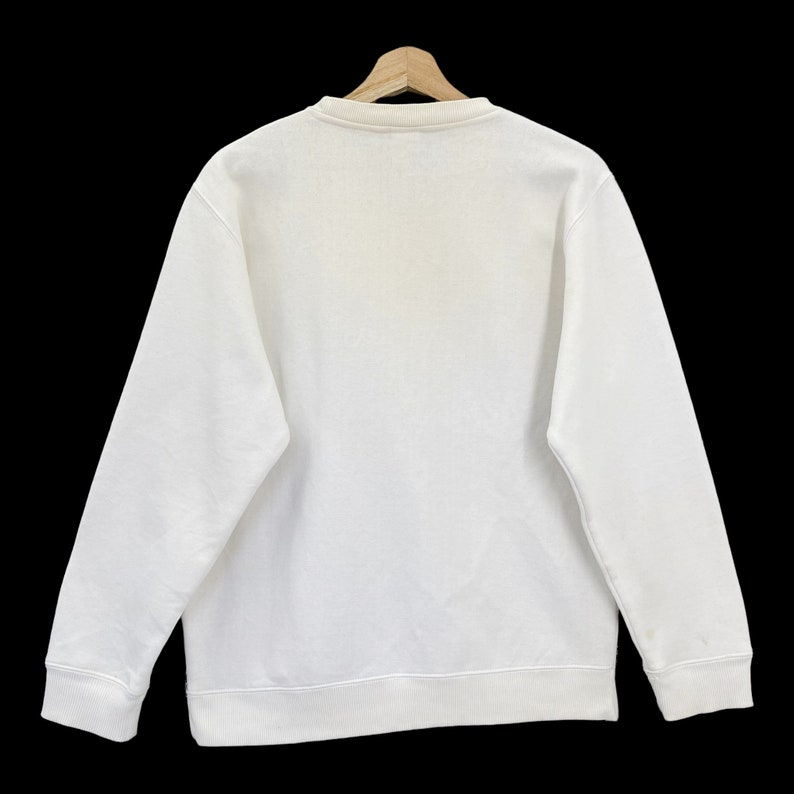 K&ouml;nnte beinhalten: Ein wei&szlig;er Pullover mit Rundhalsausschnitt und langen &Auml;rmeln.