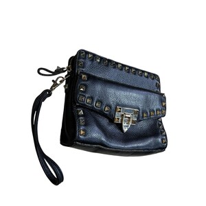 May include: Black leather crossbody bag with gold-tone pyramid studs. The bag features a flap closure with a silver-tone clasp and a wrist strap. The bag is rectangular in shape and has a textured surface.