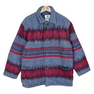 May include: A gray wool coat with a red and gray geometric pattern. The coat has a button-up front, two pockets, and a collar. The brand name "Wonder Bear" is visible on the label.
