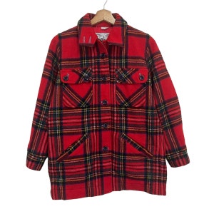 May include: Red plaid jacket with a button-down front, two chest pockets, and two lower pockets. The jacket features a classic plaid pattern in red, black, yellow, and green. The jacket is hanging on a wooden hanger.