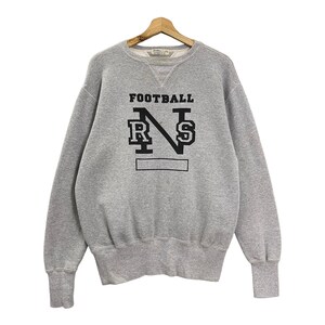 May include: A grey sweatshirt featuring the word "FOOTBALL" above a black graphic with the letters "R", "N", and "S". The sweatshirt has a crew neck and ribbed cuffs.