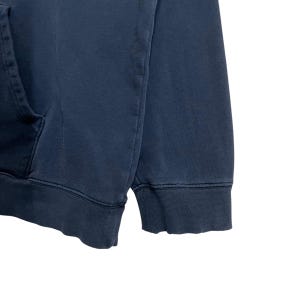 Puede incluir: Una sudadera con capucha azul oscuro con un bolsillo canguro y pu&ntilde;os de canal&eacute;.