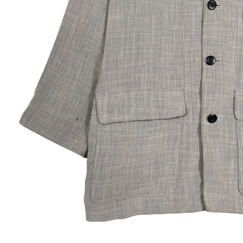 May include: A brown linen jacket with a single chest pocket and two button closures.