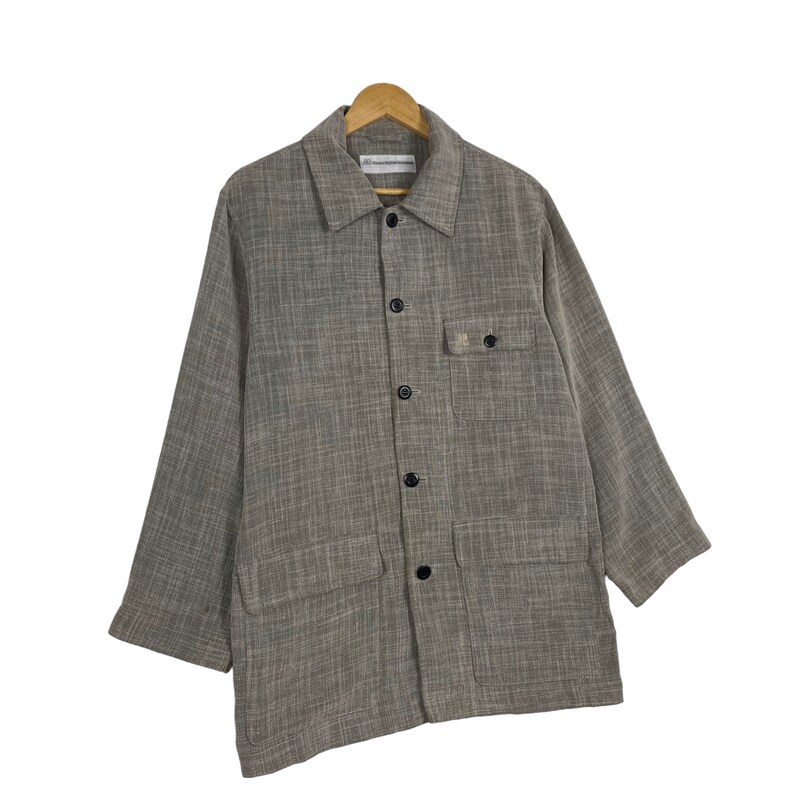 May include: A gray and white checkered long-sleeved shirt with a button-up front and two large pockets. The shirt has a relaxed fit and a collar.