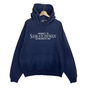 May include: A navy blue hooded sweatshirt with the text "University of Saskatchewan Established in 1907" in white.