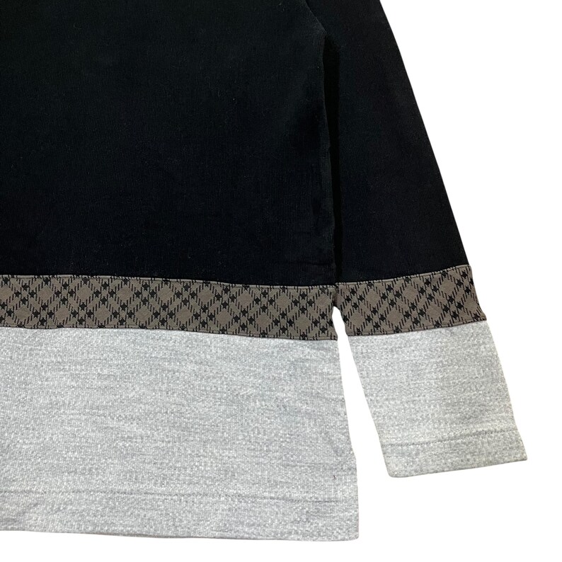 May include: Black long-sleeve shirt with a gray lower section and sleeves. A brown and black checkered pattern separates the black upper section from the gray lower section. The sleeves are long and end in a gray cuff.