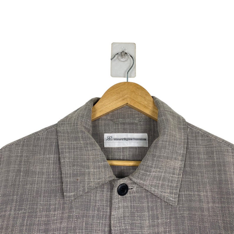 May include: A gray linen jacket with a button closure and a small label that reads "our legacy" on the left side of the chest.