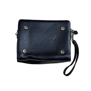 May include: Black leather clutch with a wrist strap. The rectangular bag has four metal snap closures and a silver-tone zipper. The leather has a textured appearance. The clutch is designed to be carried by hand.