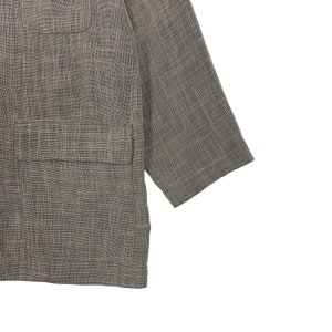 May include: A gray linen blazer with a textured weave. The blazer has a single button closure and two pockets.
