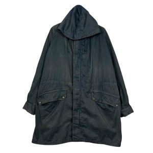 Puede incluir: Parka con capucha verde oscuro con cordón y dos bolsillos delanteros grandes. El abrigo largo tiene cierre de botón y cremallera y está hecho de un material duradero y resistente a la intemperie. Chaqueta de estilo vintage.