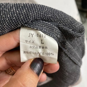May include: A white tag with black text that reads "JY-8612", "サイズ L", "法定品質表示", and "表地ポリエステル 100%".