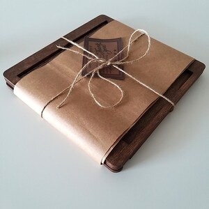 May include: A wooden book stand wrapped in brown paper with twine and a small brown tag that says "Thank You".