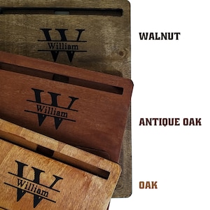 Op de afbeelding: Houten lapdesks in walnoot, antiek eiken en eiken afwerkingen. Elk bureau heeft een gepersonaliseerd ontwerp met de naam "William" en een gestileerde initiaal "W". De bureaus hebben een sleuf voor een tablet of telefoon.