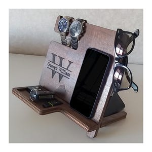 May include: A wooden organizer with a personalized monogram, "George William", and slots for watches, a phone, keys, and sunglasses.