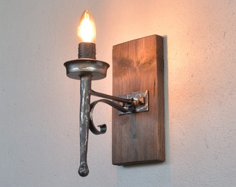 Aplique de hierro forjado con forma de antorcha: decoración de pared de inspiración medieval.
