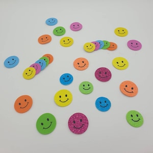 Könnte beinhalten: Sortiment an bunten Smiley-Aufklebern mit Glitzer. Die Aufkleber sind in verschiedenen Farben, darunter Gelb, Blau, Grün, Pink, Orange und Rot.