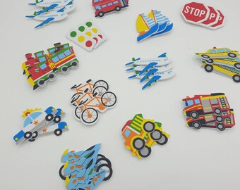 May include: A set of colorful foam stickers featuring various modes of transportation, including airplanes, a train, a bus, a boat, a truck, a police car, a fire truck, a bicycle, and a stop sign.