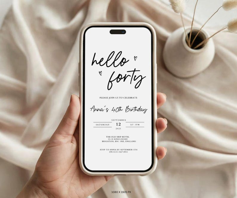 May include: A smartphone displays a birthday invitation with the words "hello forty" in elegant script. The invitation includes details for Anna's 40th birthday celebration, with the date and location. The phone is held against a soft, neutral-toned background.