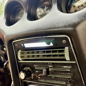May include: A black automotive dashboard center console featuring horizontal air vents, manual sliding climate control levers labeled AIR VENT, TEMP, and DEF, a fan speed knob, and a Boss Audio Systems head unit with Bluetooth connectivity.