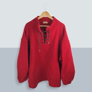 May include: Red sweater with a lace-up neckline and long sleeves.