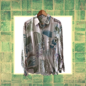 May include: A long-sleeved button-up shirt with an abstract print in shades of brown, green, blue, and purple.