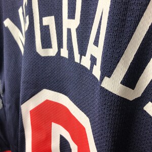 May include: A navy blue jersey with white lettering that reads "GRAZ"