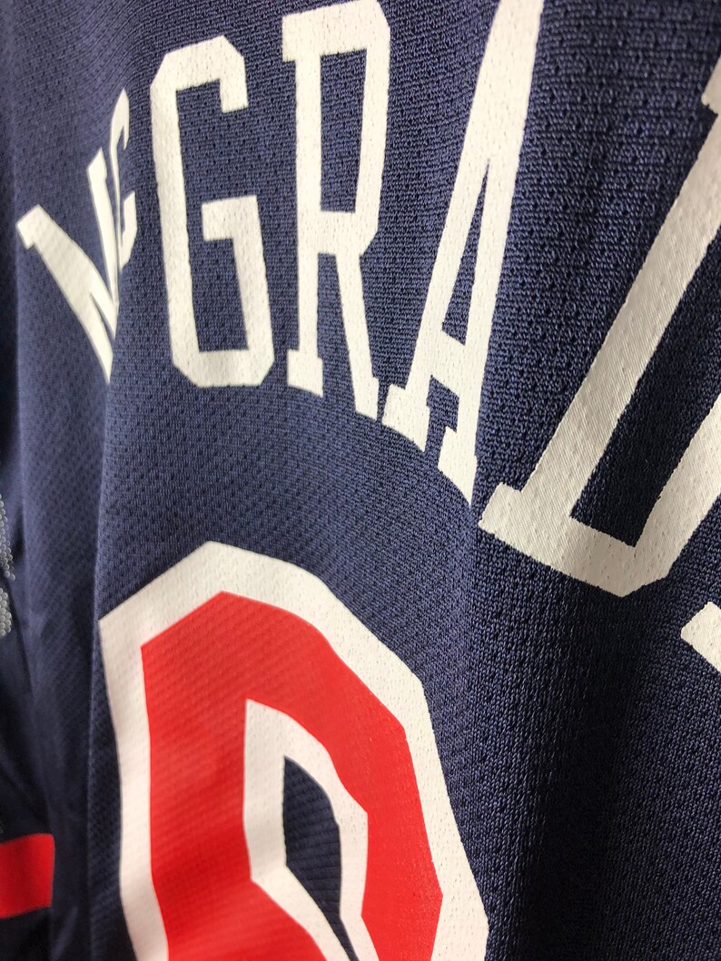 May include: A navy blue jersey with white lettering that reads "GRAZ"